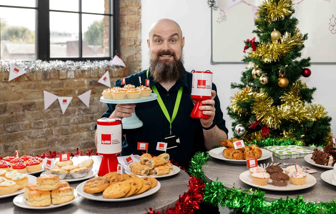 Man in Christmas jumper hosting a bake sale